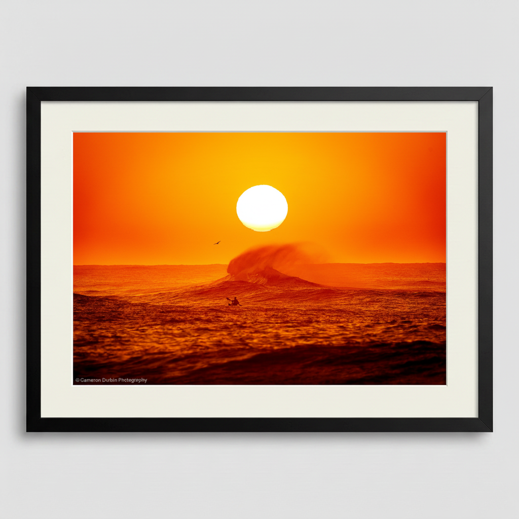Framed artwork of a sunset over the ocean with a surfer and wave. Northern Beaches Sydney Long Reef