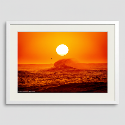 Framed artwork of a sunset over the ocean with a surfer and wave. Northern Beaches Sydney Long Reef