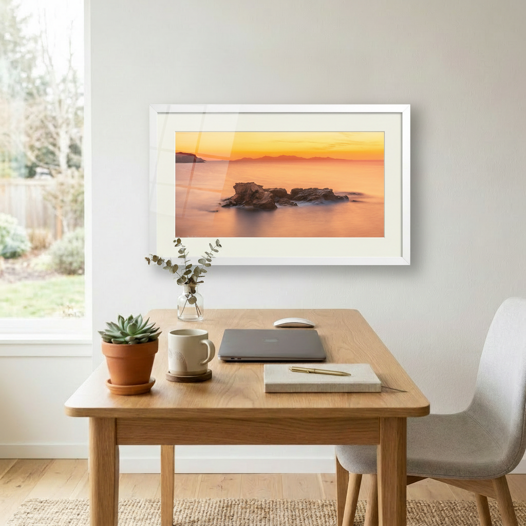 A photograph depicting a sunset over the Aegean Sea from Antiparos, Greece, with a rock formation in the foreground.