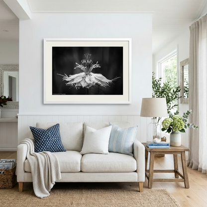 Living room with a white sofa, decorative pillows, and a framed black and white artwork on the wall.